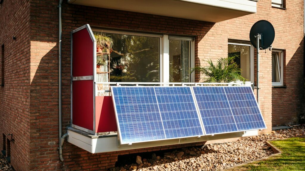 Balkonkraftwerk mit Speicher: Solarmodule am Balkon eines Backsteinhauses