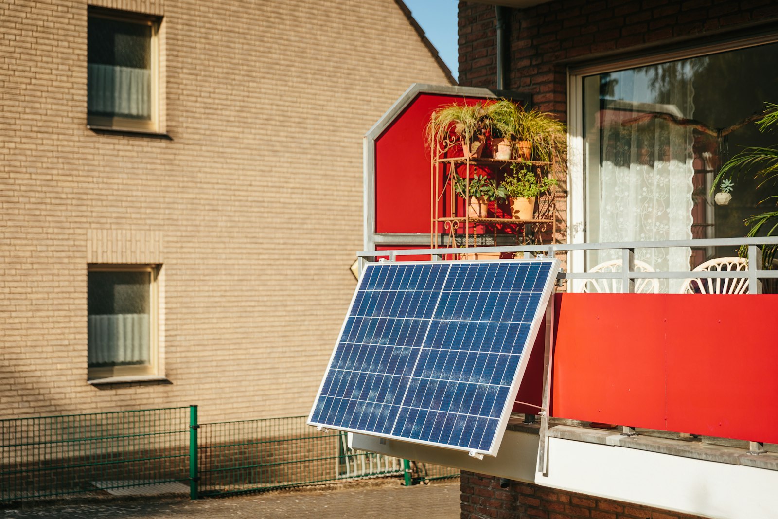 Balkonkraftwerk mit Speicher: Solarmodul am Balkon zwischen Pflanzen