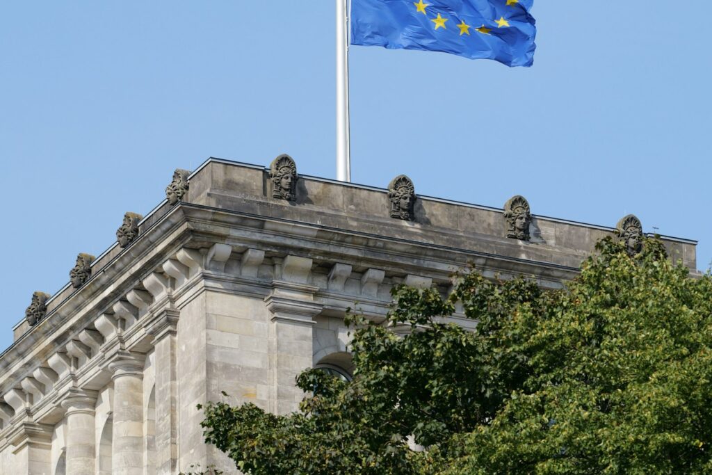 Flagge der Europäischen Union weht über einem Steingebäude