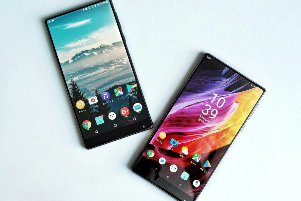 Zwei Smartphones nebeneinander auf einer weißen Fläche