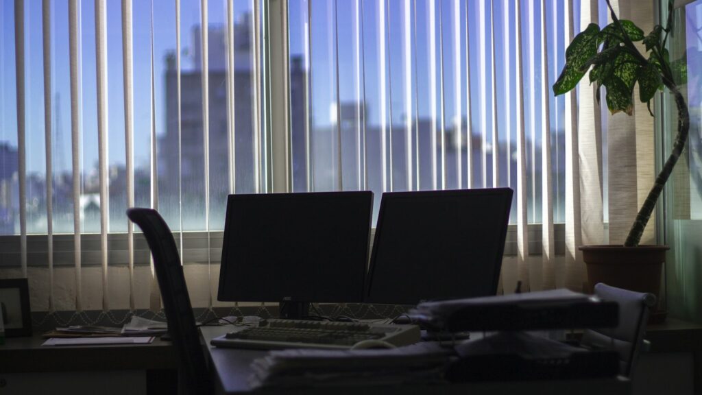 Arbeitsplatz mit zwei Monitoren am Fenster, an dem KI-Agenten eingeführt werden