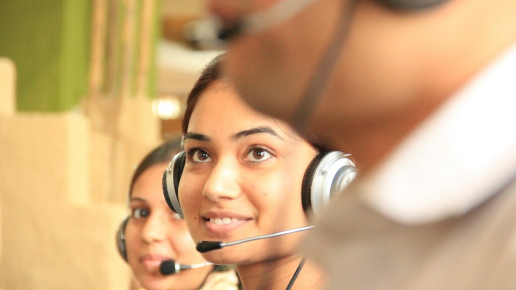 Zwei Frauen mit Headsets arbeiten in einem hellen Büro – KI-Kundenservice entlastet das Serviceteam