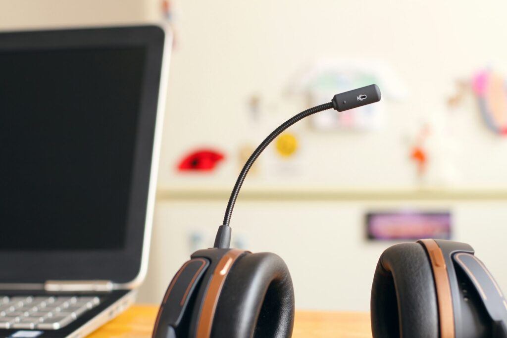 Headset liegt neben einem aufgeklappten Laptop