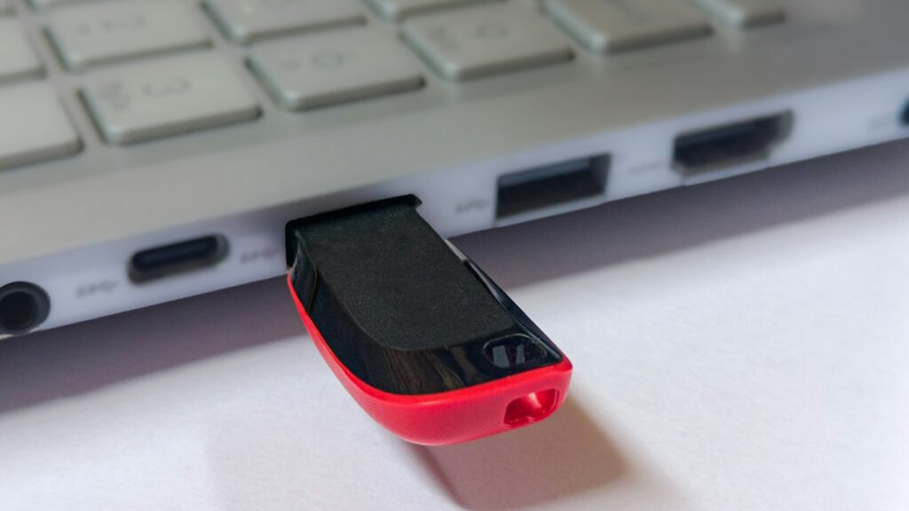 USB-Stick steckt in einem silbernen Laptop: Linux Umstieg per Live-System