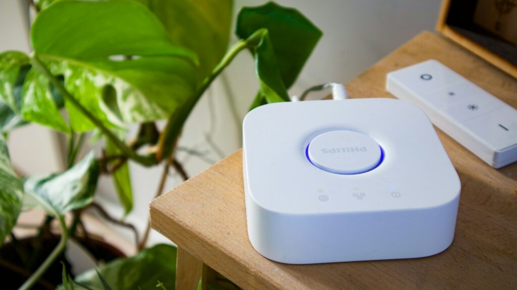 Smart-Home-Zentrale und Fernbedienung auf einem Holztisch als Steuerzentrale im Matter Smart Home
