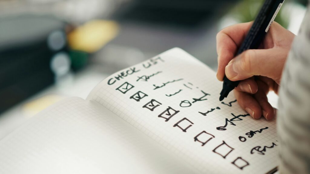 Hand hakt Punkte auf einer Checkliste ab