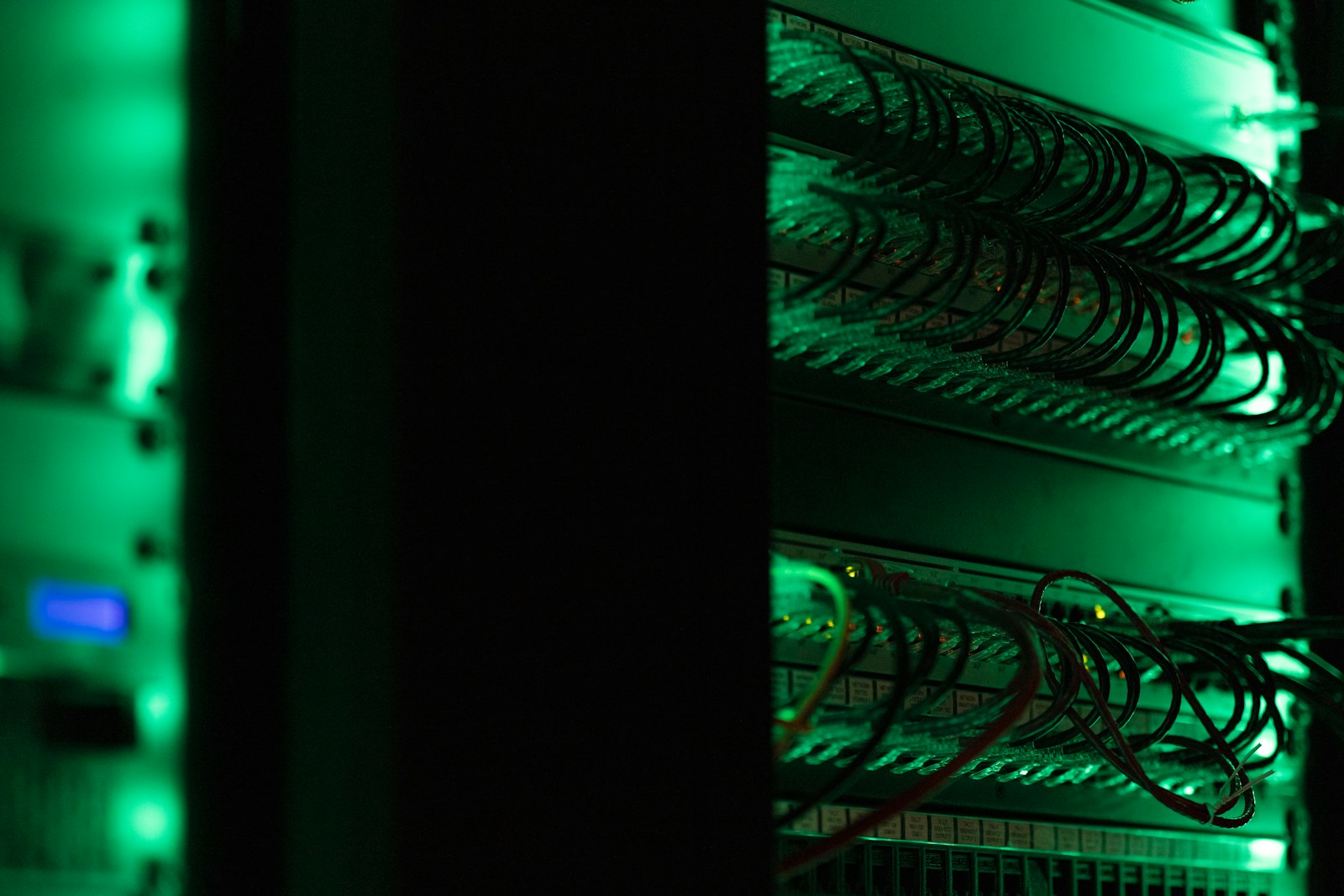 Serverschrank mit Netzwerktechnik in einem dunklen Rechenzentrum