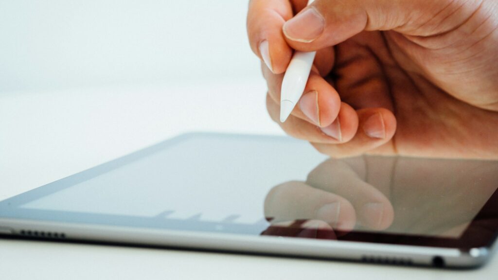 Hand mit Eingabestift über einem Tablet für handschriftliche Notizen