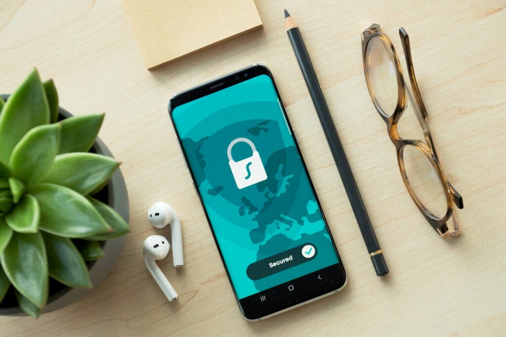 Smartphone mit Schloss-Symbol auf einem Holztisch neben einer Sukkulente