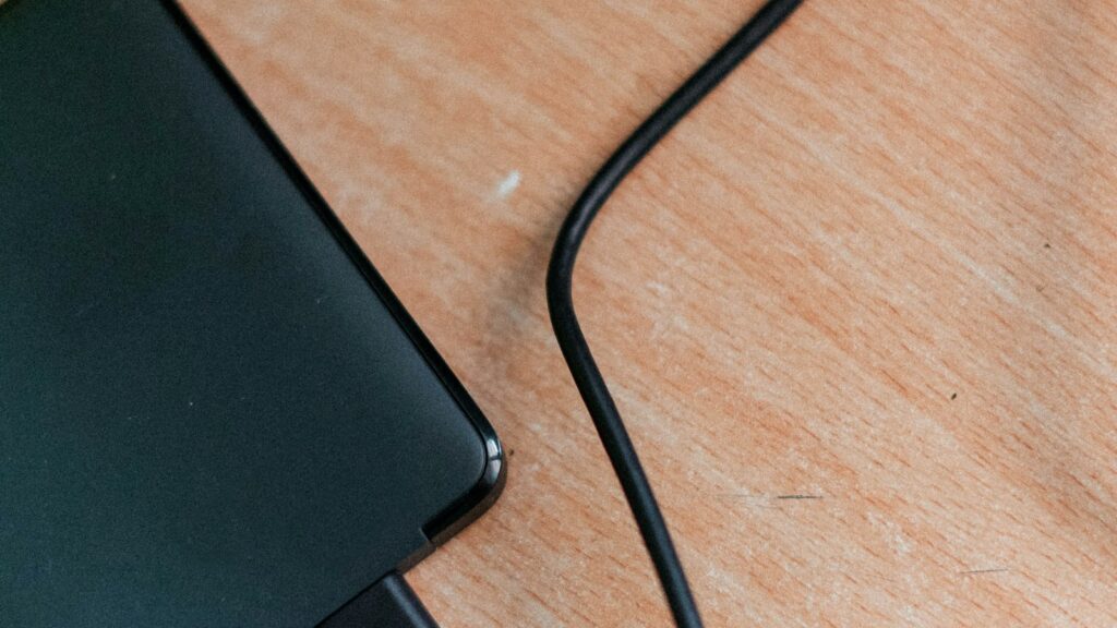 Schwarze Powerbank auf einem Holztisch