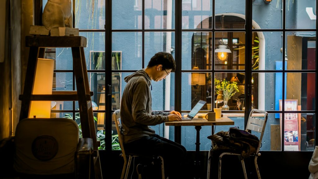Mann arbeitet im Café am Laptop
