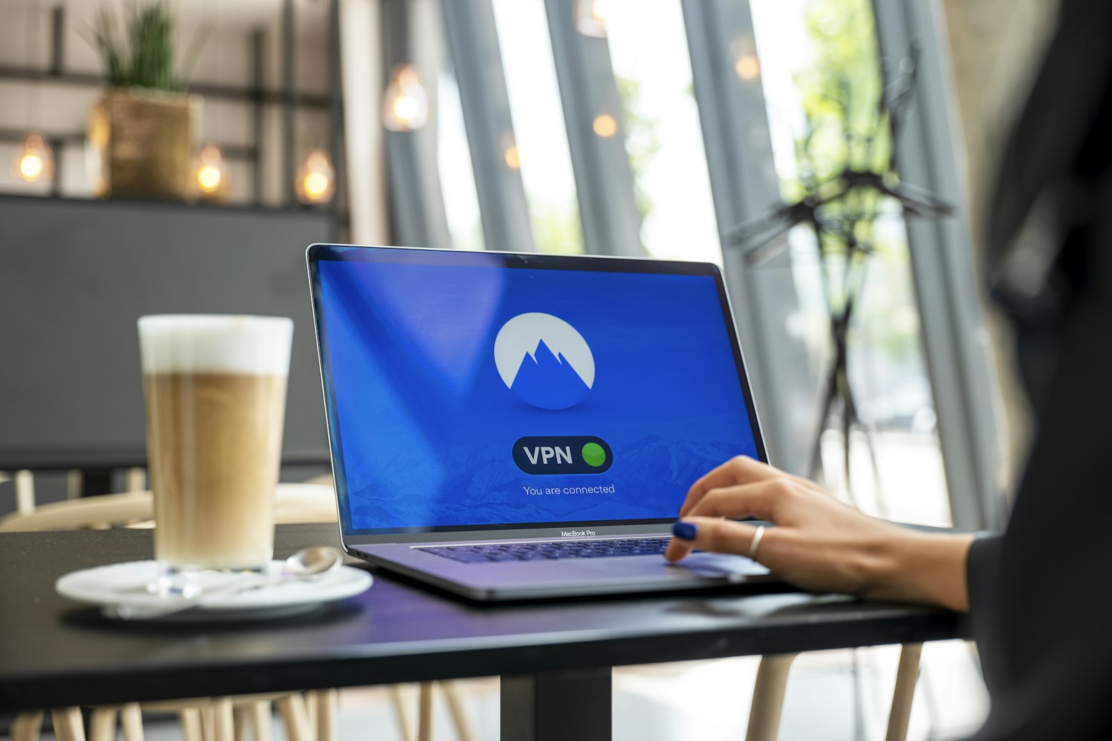 Person arbeitet an einem schwarzen Laptop
