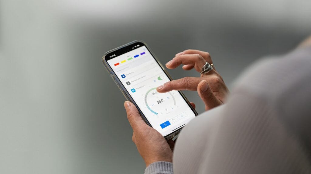 Hände halten ein Smartphone mit geöffneter App