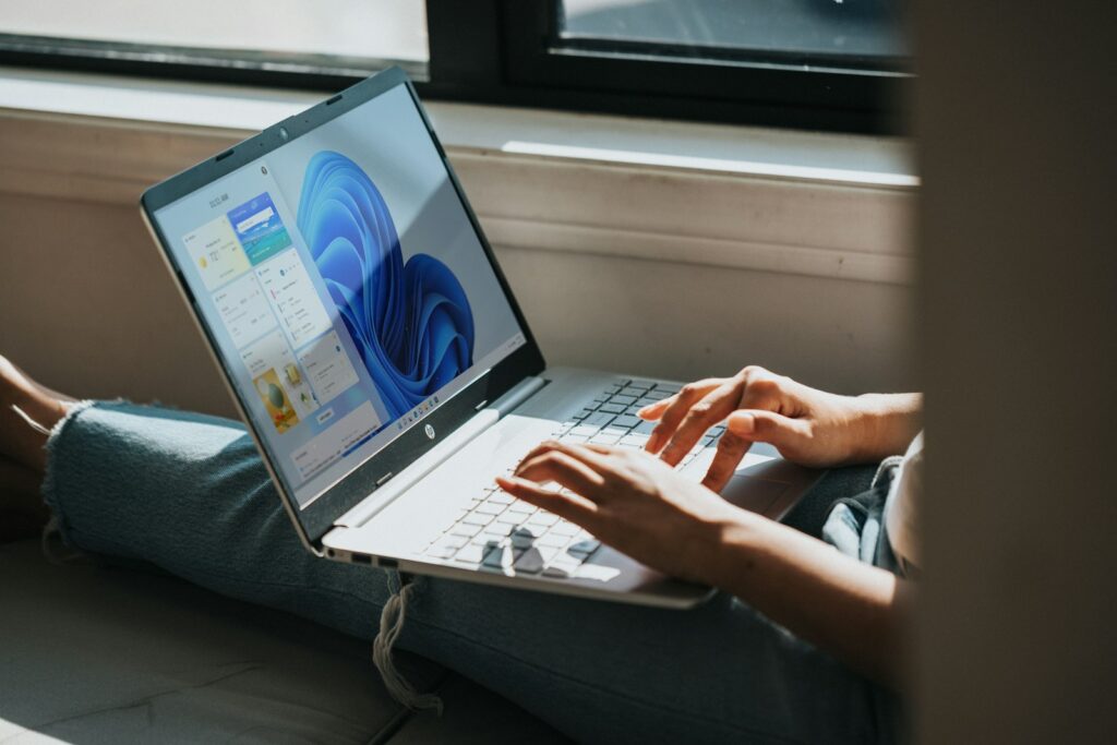 Person nutzt einen Laptop mit Windows 11 auf dem Schoß