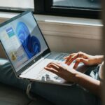 Person nutzt einen Laptop mit Windows 11 auf dem Schoß
