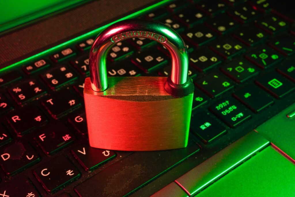 Rotes Vorhängeschloss auf einer schwarzen Computertastatur