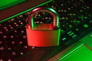 Rotes Vorhängeschloss auf einer schwarzen Computertastatur